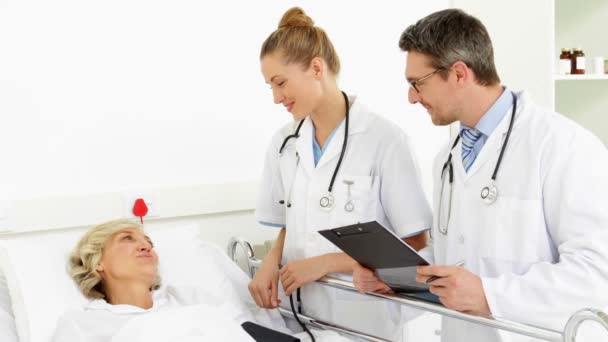 Médicos falando com paciente doente na cama — Vídeo de Stock