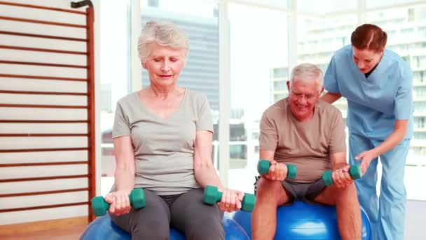 Dos personas mayores haciendo ejercicio con fisioterapeuta — Vídeo de stock