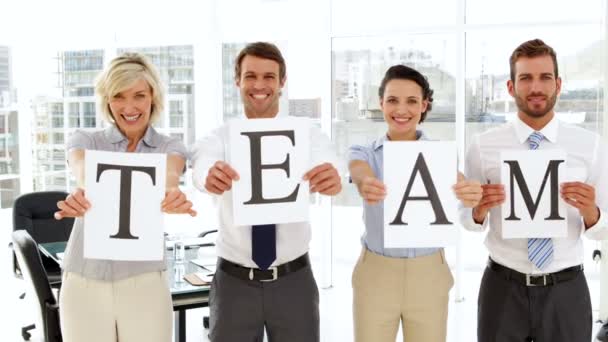 Business people holding up pages spelling out team — Stock Video
