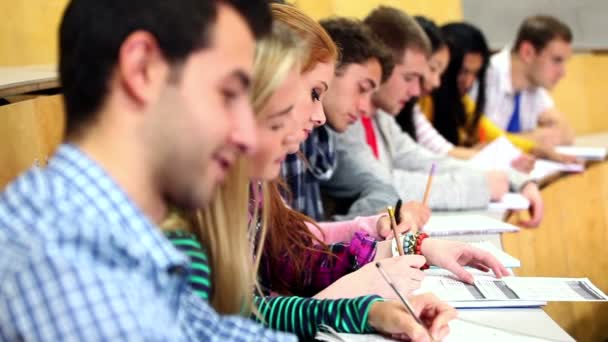 Fila de estudiantes felices escuchando en una sala de conferencias — Vídeos de Stock