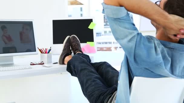 Photo editor relaxing at his desk — Stock Video