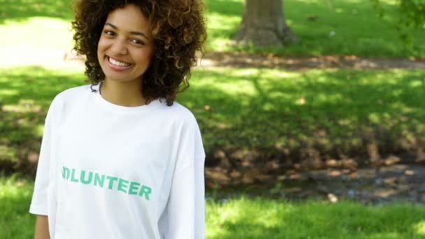 Довольно доброволец, указывающий на футболку — стоковое видео