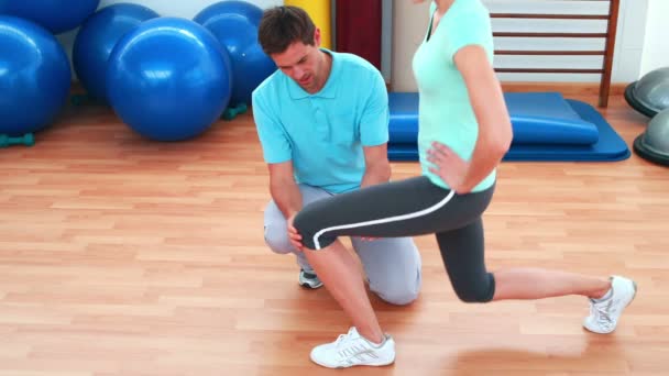 Trainer showing his client how to do a lunge correctly — Stock Footage Trainer showing his client how to do a lunge correctly Royalty Free Stock Footage