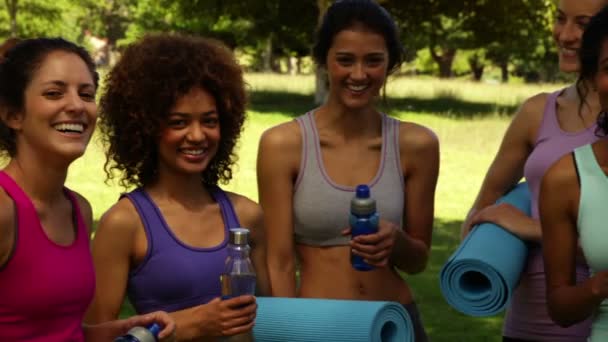 Занятия фитнесом улыбаются перед камерой перед тренировкой в парке — стоковое видео