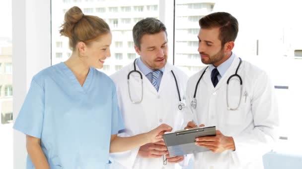 Equipo médico discutiendo papeleo en portapapeles — Vídeos de Stock