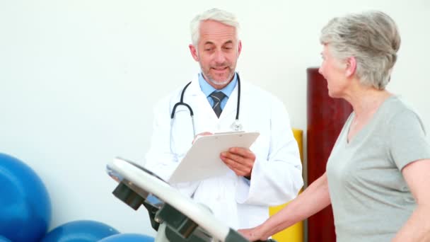 Médico observando paciente usando cinta de correr — Vídeos de Stock