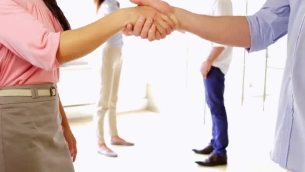 Молодые коллеги пожимают друг другу руки — стоковое видео