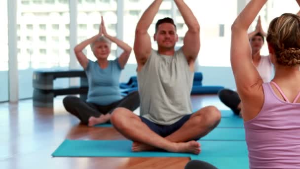 Yoga class sitting in lotus position together — Stock Footage Yoga class sitting in lotus position together Video Clip