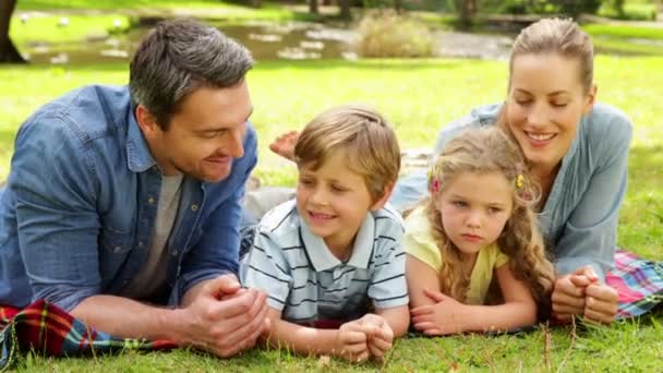 Linda familia sonriendo a la cámara en el parque — Vídeo de stock