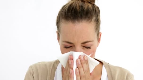 Beautiful sick woman sneezing using a tissue — Stock Video