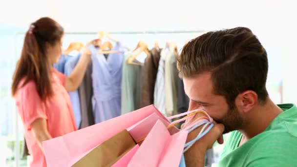 Скучный парень ходит по магазинам со своей девушкой — стоковое видео