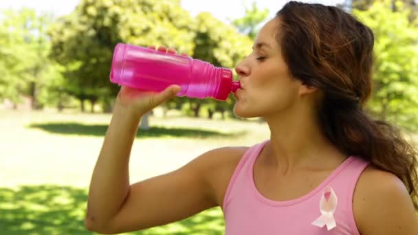 Mujer vestida de rosa para el cáncer de mama conciencia agua potable — Vídeo de stock