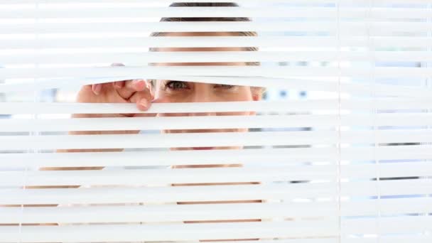 Businesswoman peeking through the blinds — Stock Video