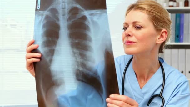 Surgeon examining xray at her desk — Stock Video