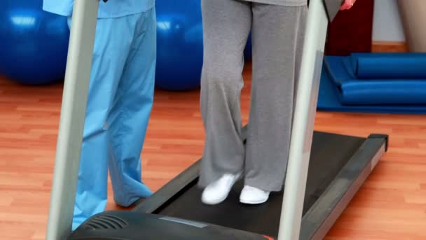 Physical therapist showing patient how to use treadmill — Stock Video