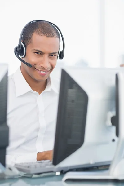 Male executive with headset using computer at desk — Stock Photo, Image