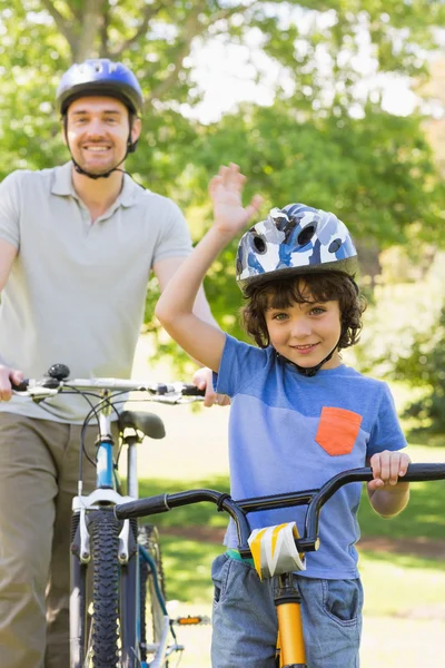 Glimlachende man met zijn zoon paardrijden fietsen — Stockfoto