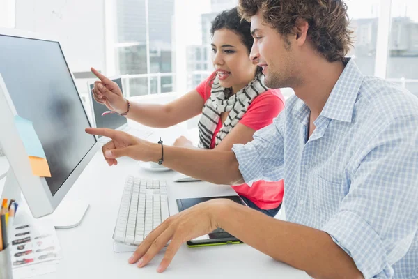 Casual couple using computer in office — Stock Photo, Image