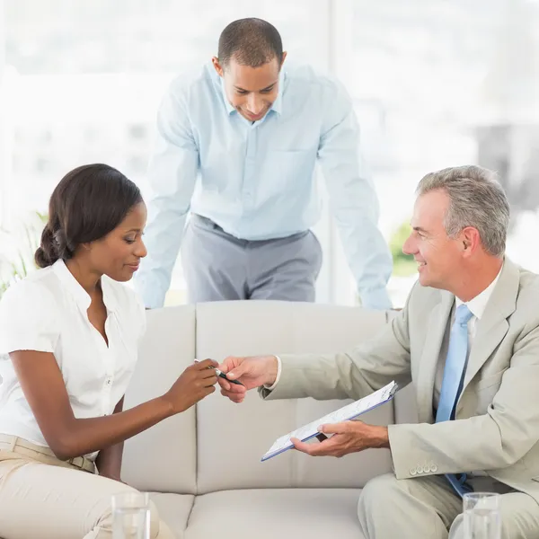 Salesman handing pen to client to sign the contract — Stock Photo, Image