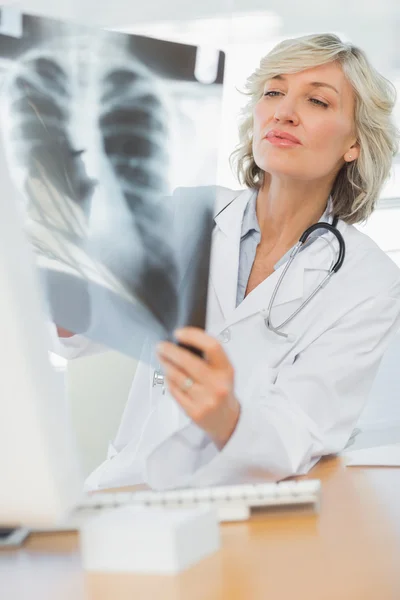 Médica séria examinando raio-X — Fotografia de Stock