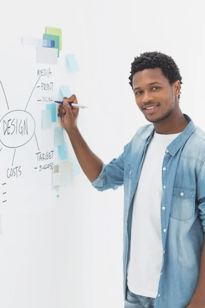 Lächelnder männlicher Künstler mit Stift vor Whiteboard — Stockfoto