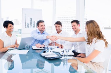 Executives shaking hands during a business meeting clipart