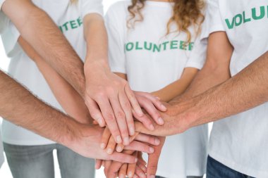 Close-up mid section of volunteers with hands together clipart