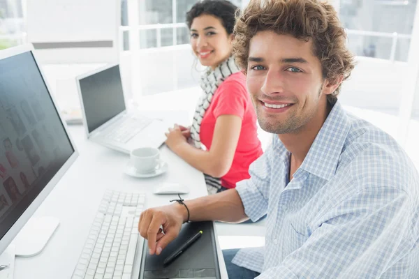 Casual couple using computers in office — Stock Photo, Image