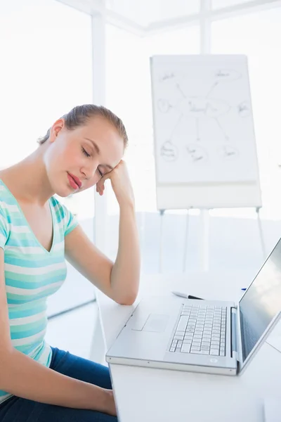 Casual woman sleeping in front of laptop at office — Stock Photo, Image
