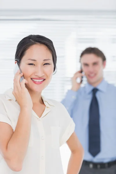 Zakenvrouw en man cellphones gebruiken in office — Stockfoto