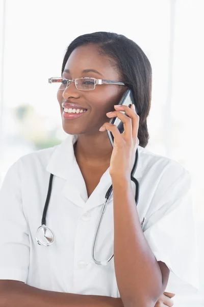 Lachende vrouwelijke arts met behulp van mobiele telefoon — Stockfoto