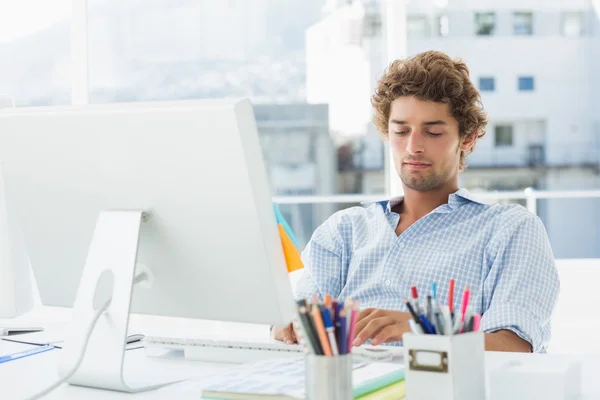 Casual giovane uomo utilizzando il computer in ufficio luminoso — Foto Stock