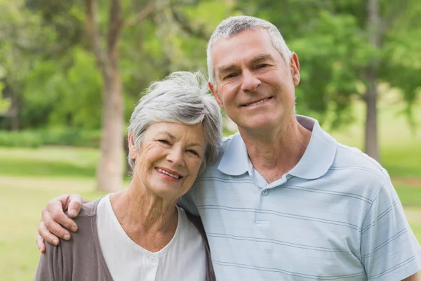 Portrait of a senior couple with arms around at park — Stock Photo, Image