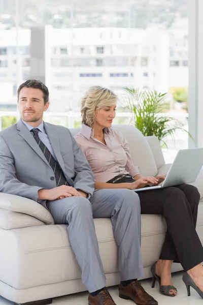 Goed geklede man met vrouw met laptop thuis — Stockfoto