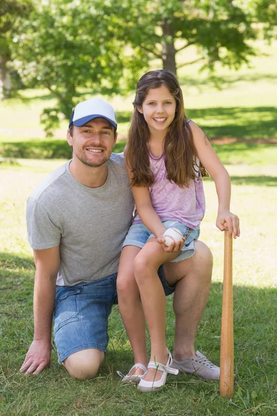 Padre e hija sosteniendo bate de béisbol en el parque — Foto de Stock