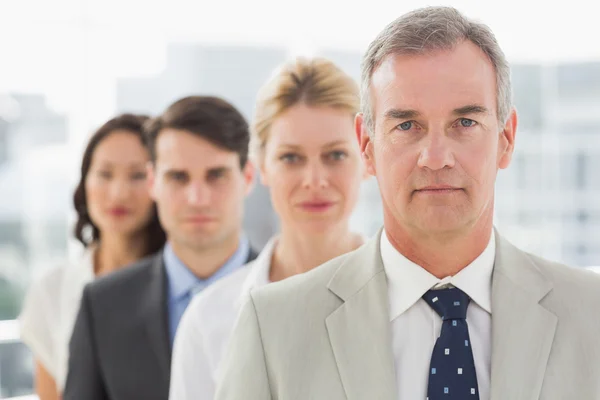 Stern business team standing in a line — Stock Photo, Image