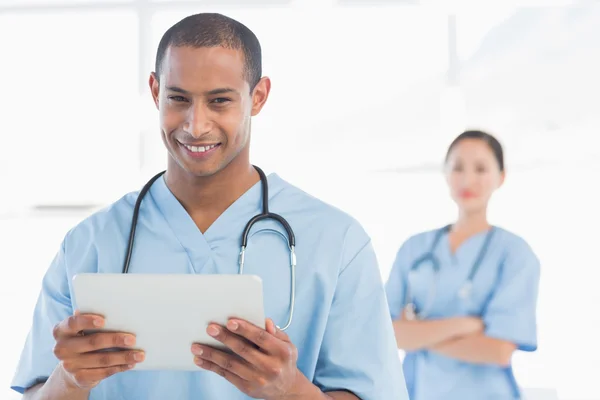 Bonito médico masculino segurando tablet digital — Fotografia de Stock