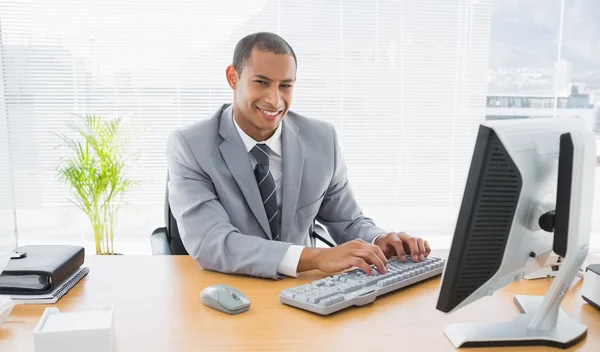 微笑在办公室使用的计算机的商人 — 图库照片