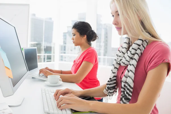 Casual unga kvinnor använder datorer i office — Stockfoto