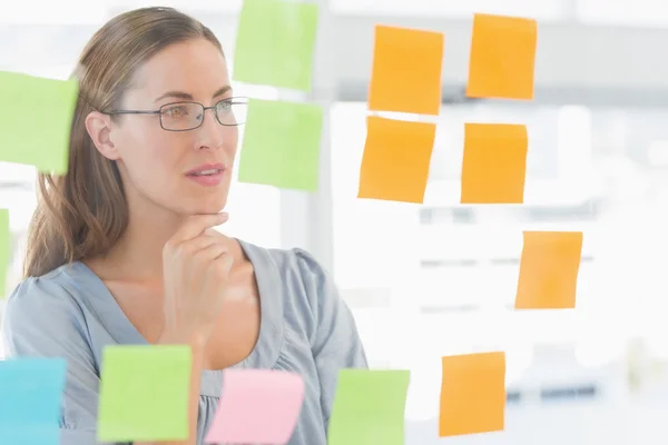 Concentrated artist looking at colorful sticky notes — Stock Photo, Image