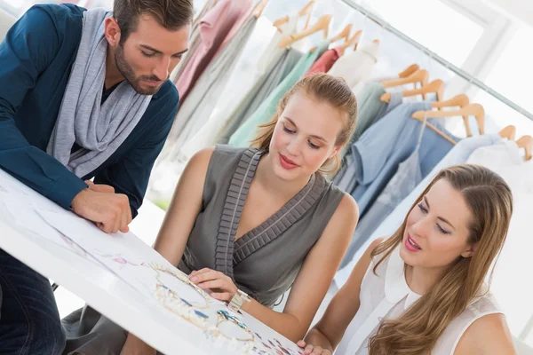 Tres diseñadores de moda discutiendo diseños — Foto de Stock