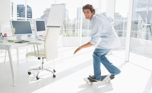 Feliz joven patinaje en una oficina brillante — Foto de Stock