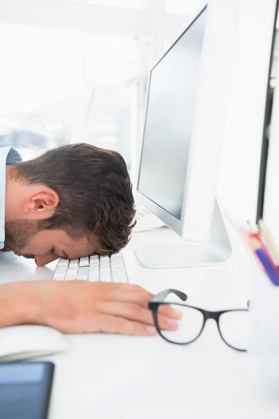 Male artist with head resting on keyboard — Stock Photo, Image