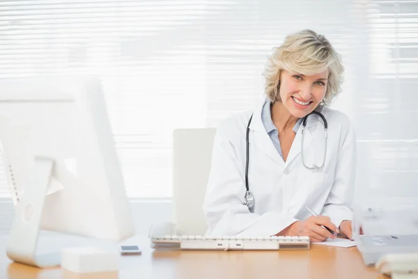 Sorridente medico femminile con computer presso lo studio medico — Foto Stock