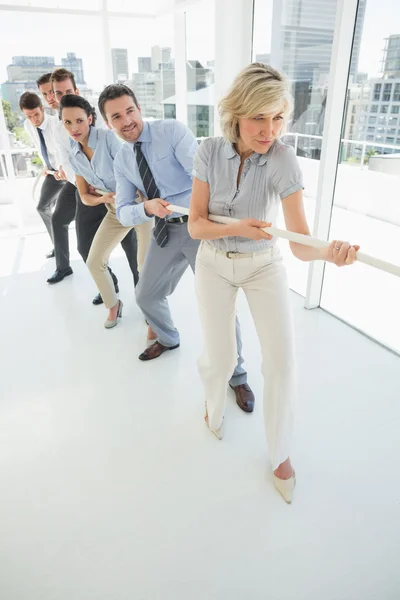 Group of business people pulling rope in office — Stock Photo, Image