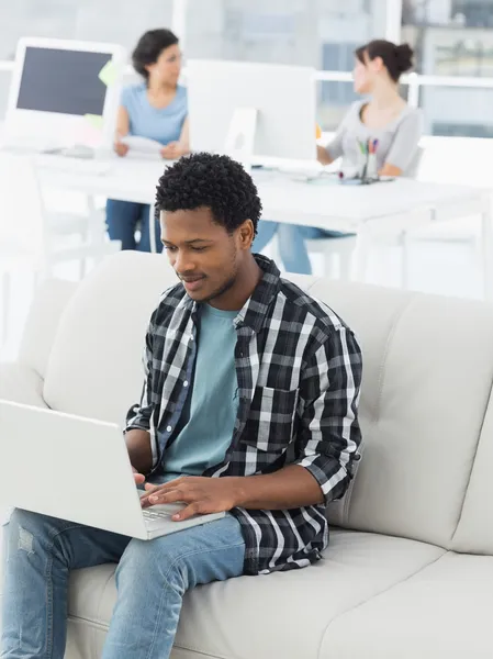 Homem usando laptop com colegas no escritório criativo — Fotografia de Stock