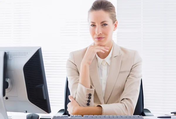 Mujer de negocios seria con computadora en el escritorio de la oficina — Foto de Stock