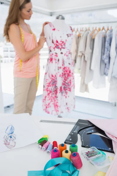 Kvinnliga modedesigner arbetar på blommig klänning på studio — Stockfoto