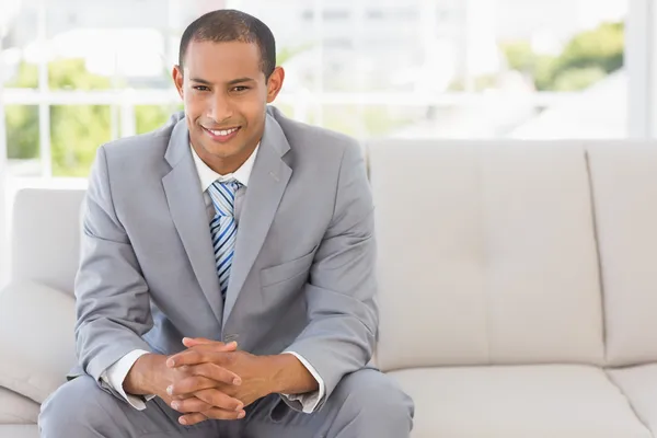 Smiling businessman sitting on couch — Stock Photo, Image