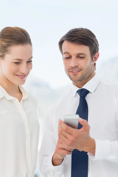 Compañeros vestidos inteligentemente mirando el teléfono móvil — Foto de Stock